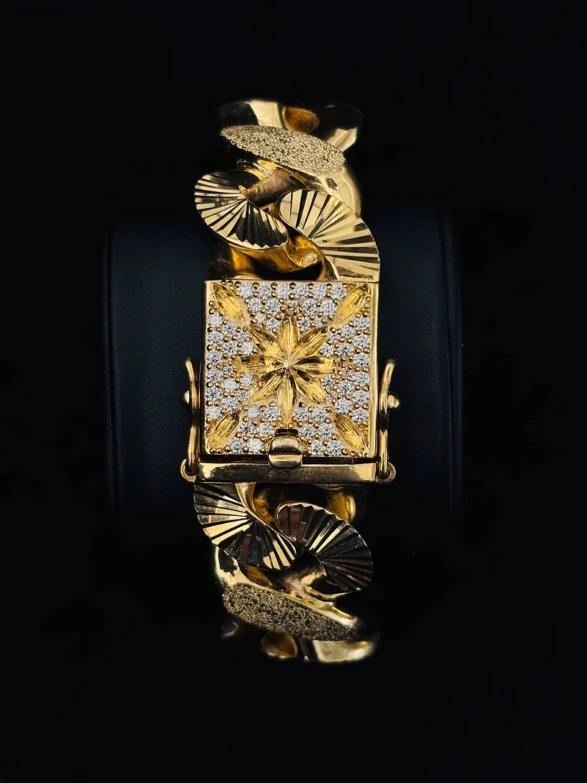 A watch with a rectangular face paved with clear stones and a starburst motif in the center