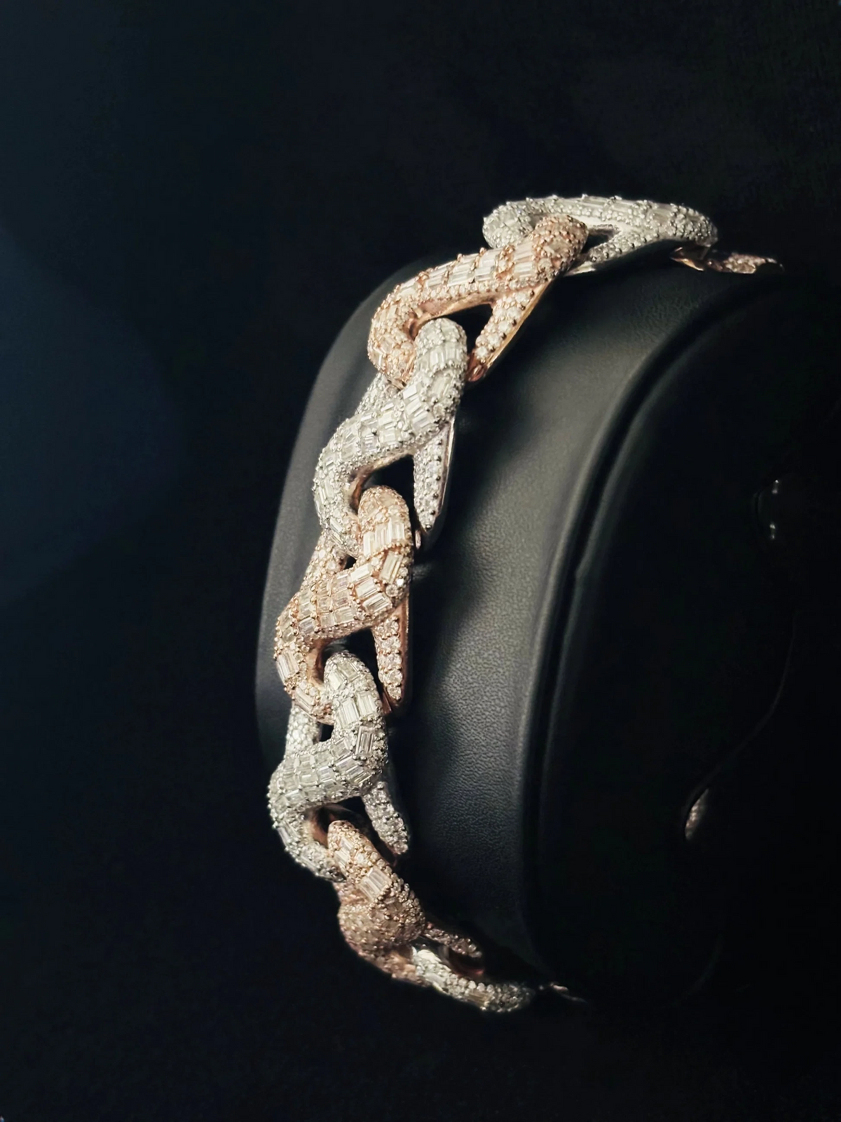A close-up of a chunky chain link bracelet with alternating two tone links, both heavily paved with diamond