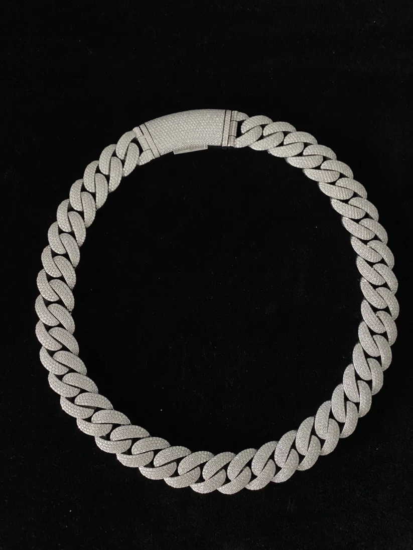 A silver Cuban link chain necklace with a textured finish and a matching textured clasp
