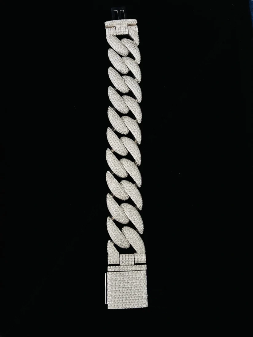 Silver diamond Cuban link bracelet with iced-out pave box clasp closure against a black background