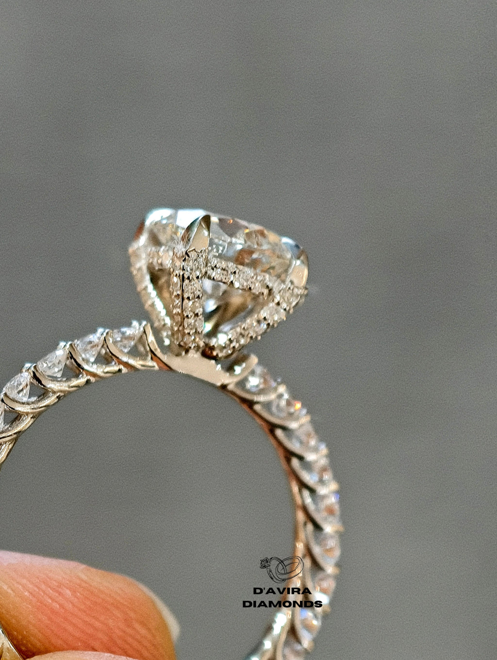 hand holding of close up view round cut hidden halo set diamond ring