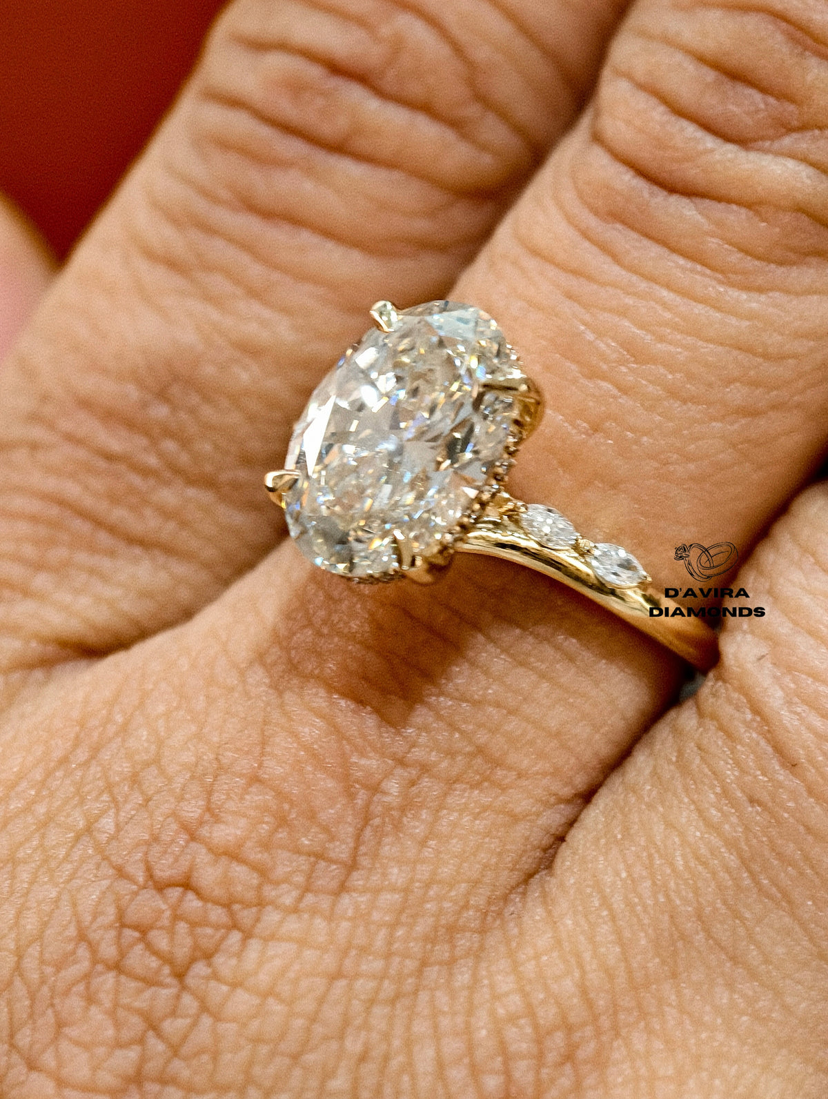 Close-up of an oval-cut diamond engagement ring on a finger
