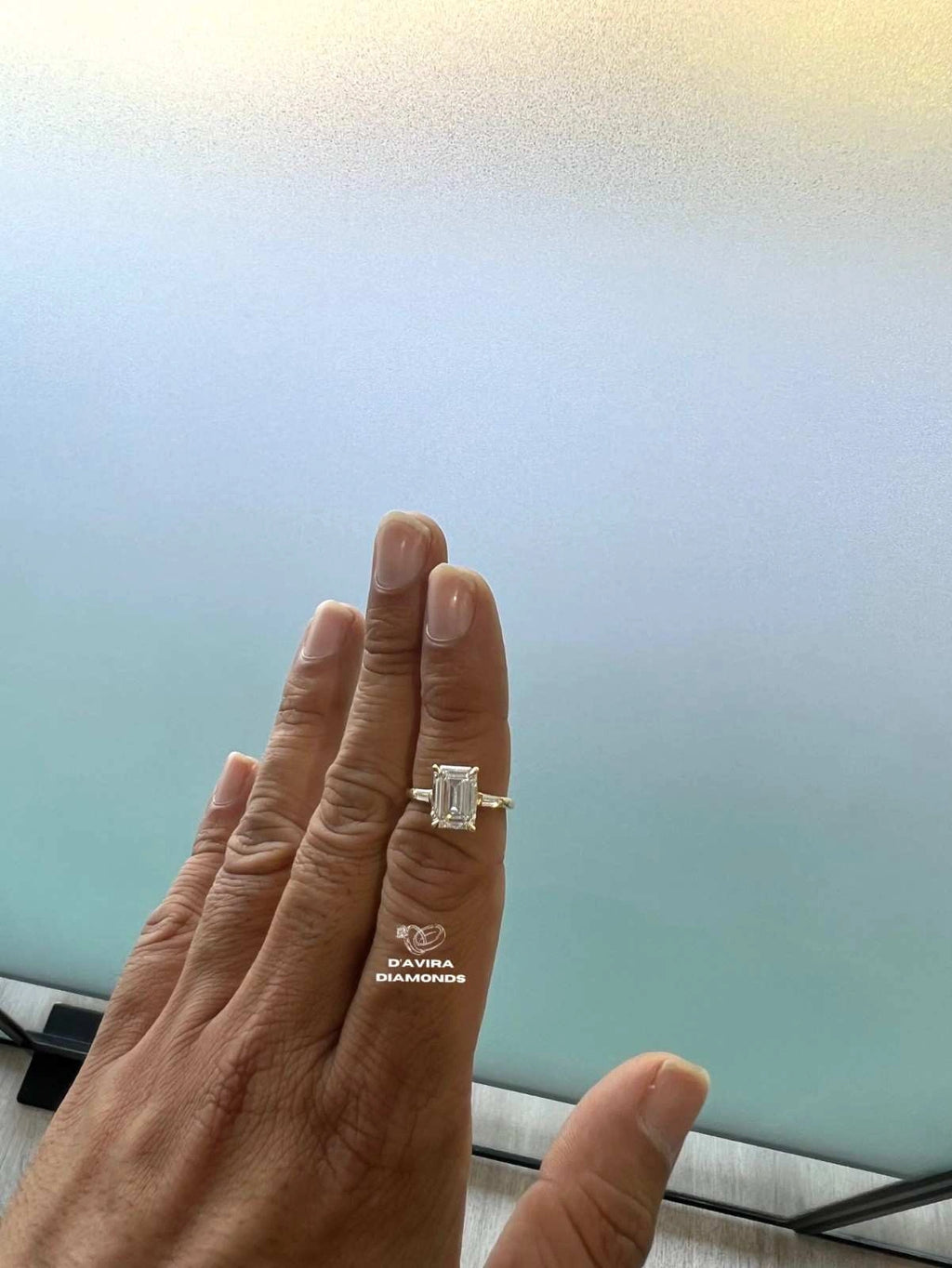 hand wearing with a emerald cut diamond ring for her