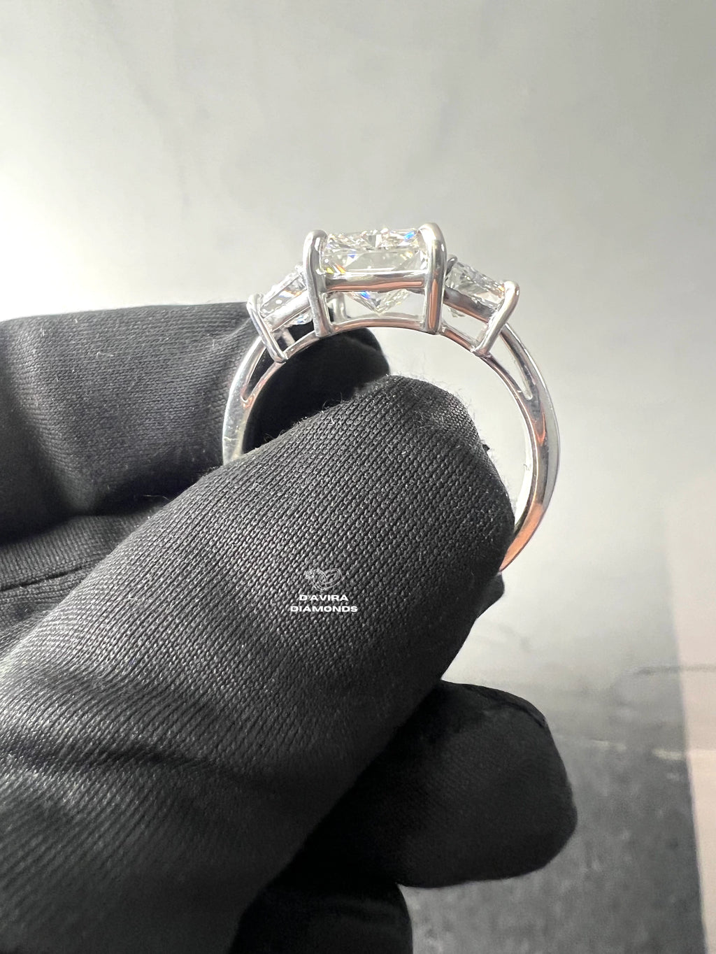 side view of the three-stone diamond engagement ring in a white gold basket setting