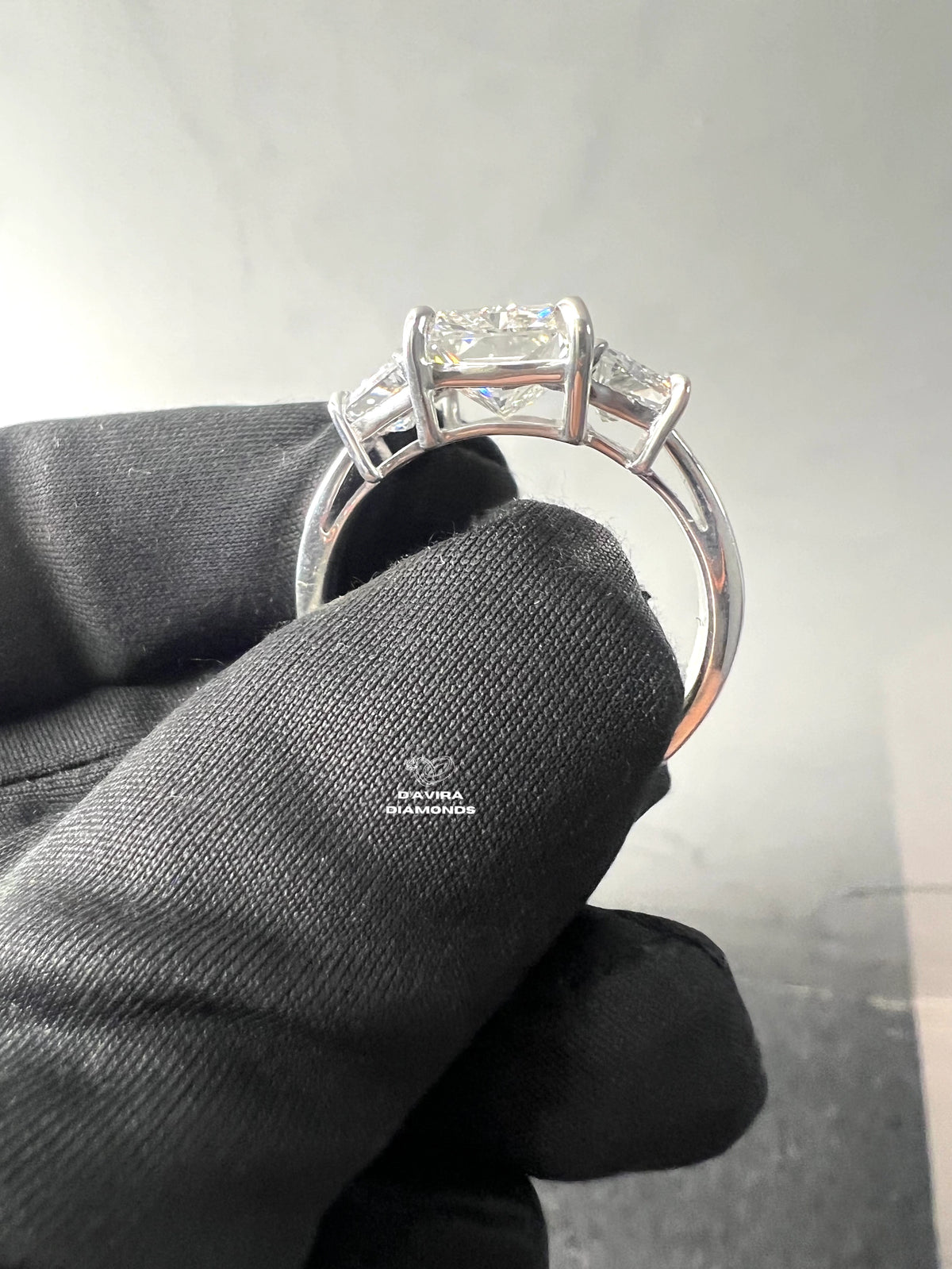 side view of the three-stone diamond engagement ring in a white gold basket setting