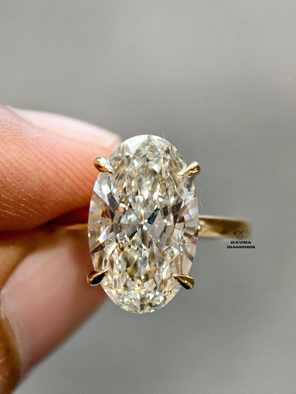  front view of the Large oval cut diamond with a yellow gold band and four prongs