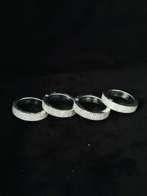 Four silver iced-out bands pave diamond multi-finger hip-hop rings lined up on a black background