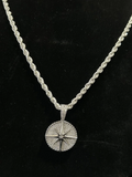 Close-up of a silver diamond-encrusted compass pendant necklace