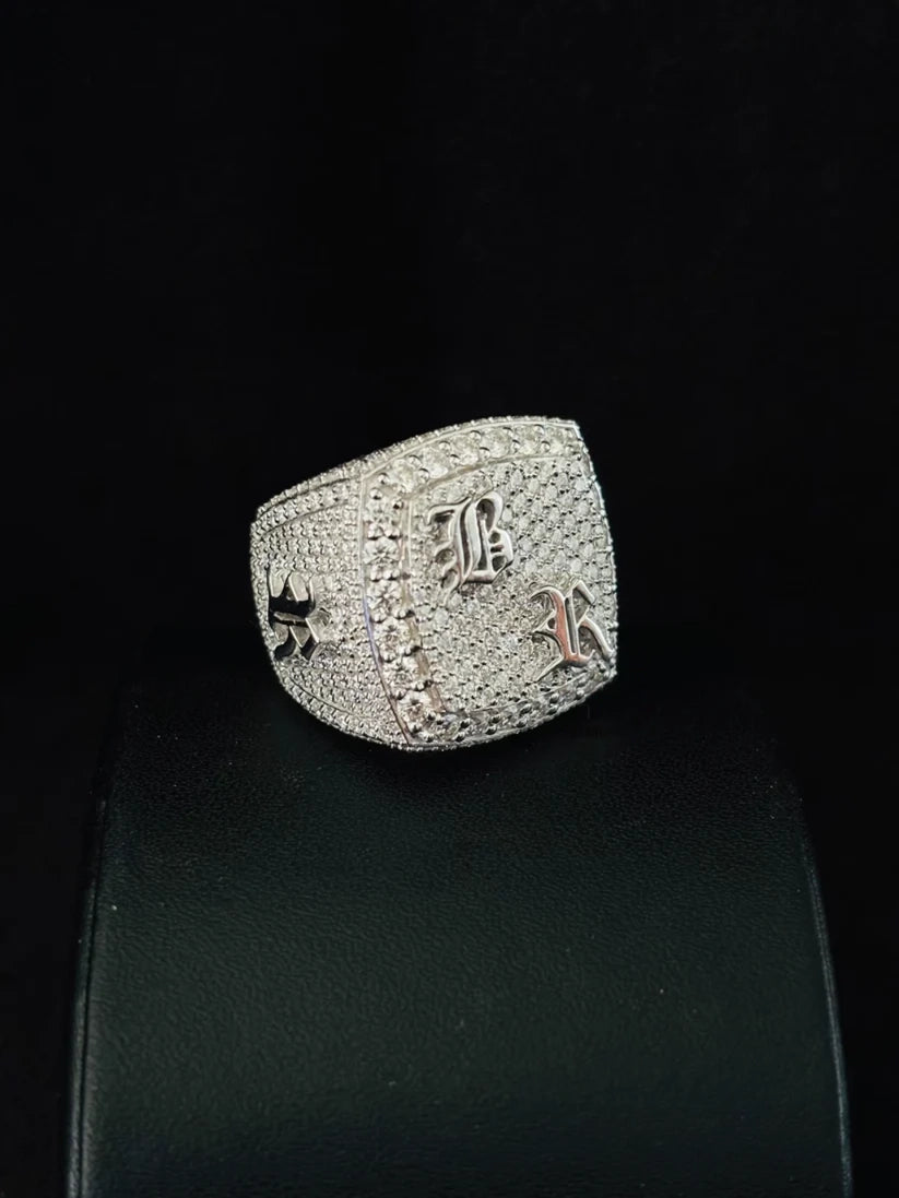 A side view silver ring covered moissanite diamond gothic-style letters on the front 