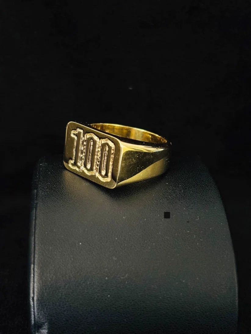gold plated signet ring with the number '100' engraved on its face a side view 