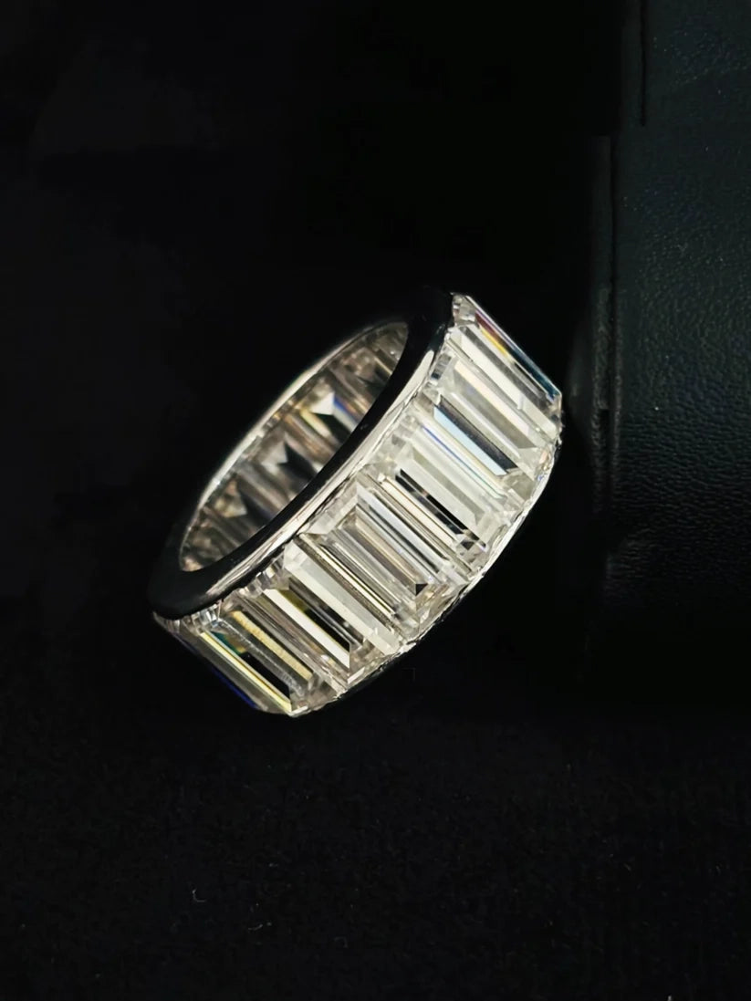 A side view silver band ring featuring a row of baguette-cut diamond, photographed