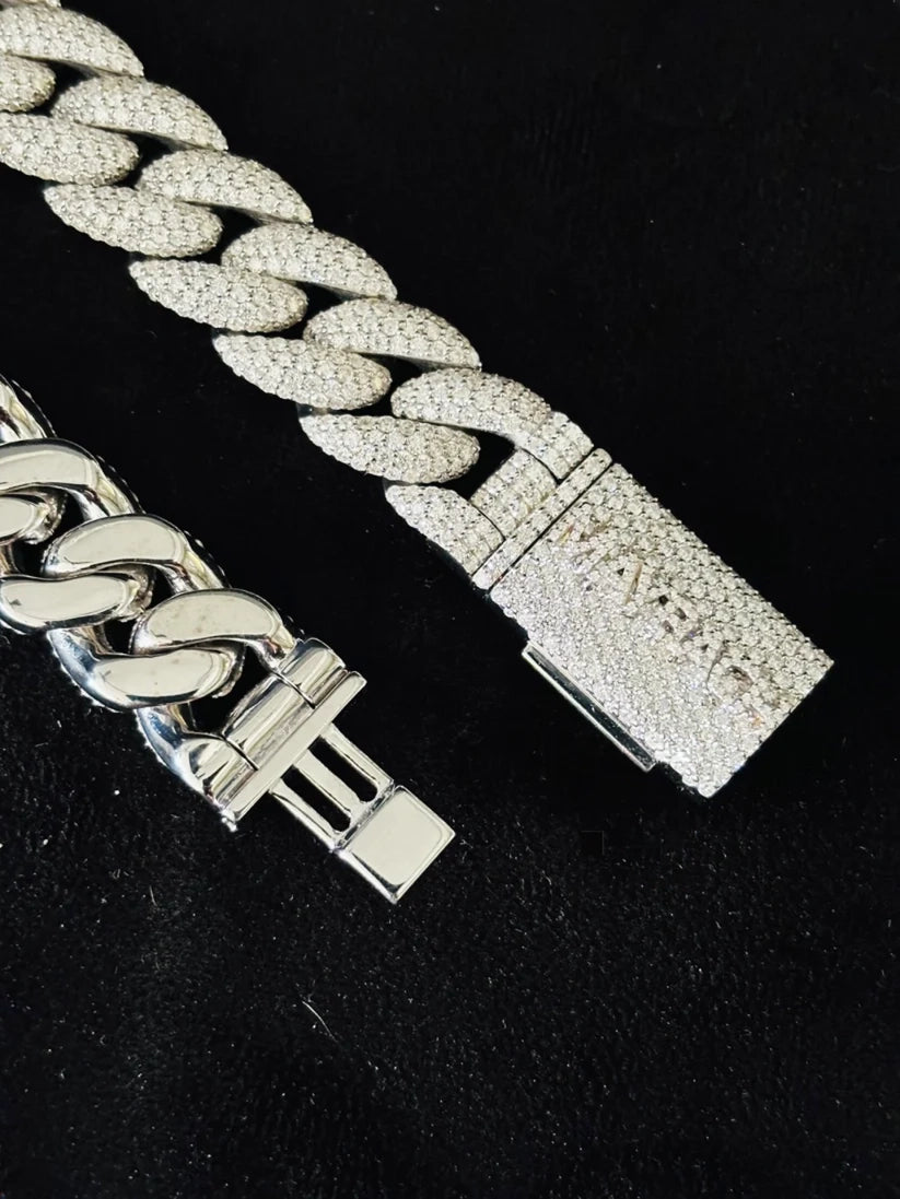 Silver hip hop style Cuban link bracelet studded with diamonds against a black background