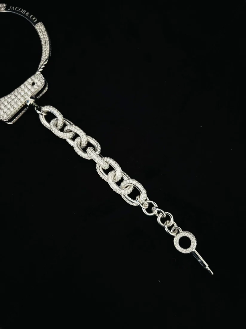 A close-up view a silver jewelry bracelet and with chain link bust down bracelet on black background
