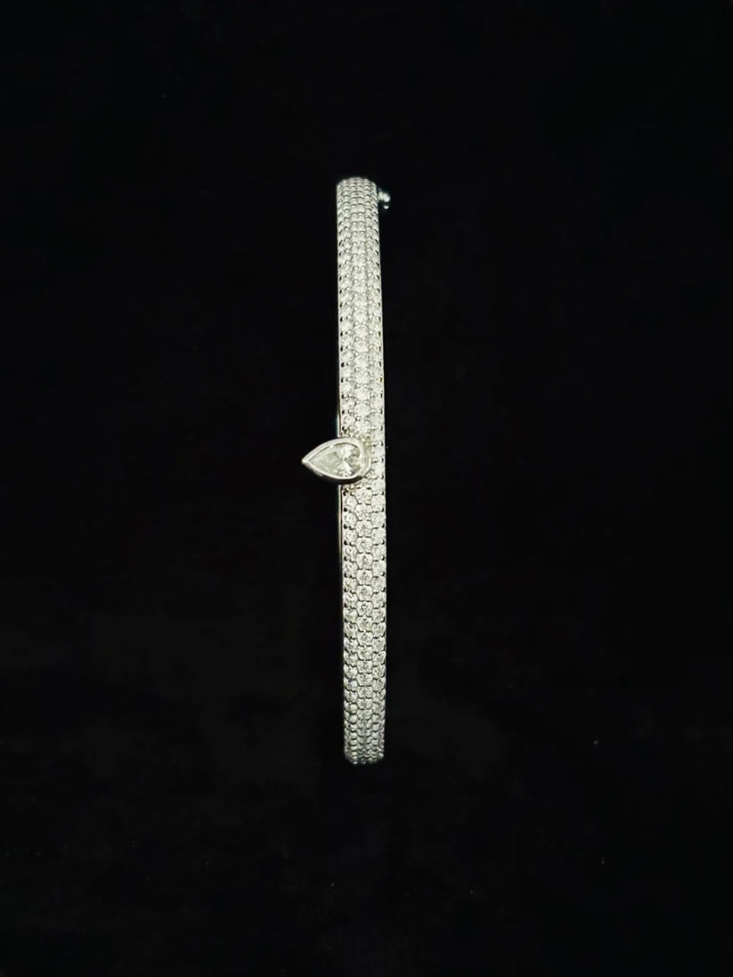 side view Luxury women's pave diamond bangle with pear cut diamond charm centerpiece