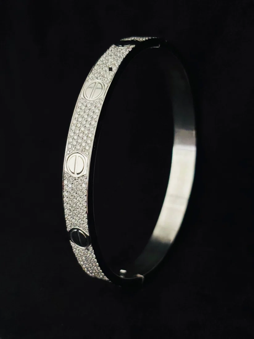 side view bangle bracelet with pave detailing motifs, displayed a black background