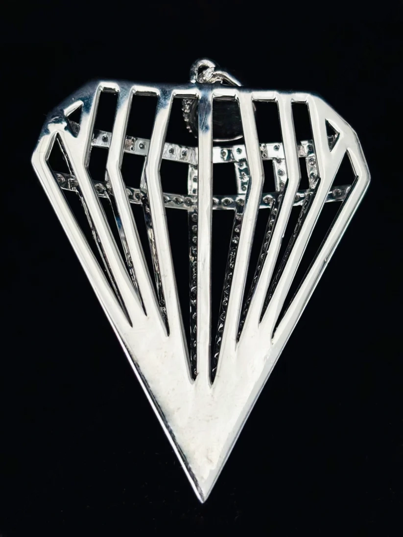 Diamond-shaped silver pendant with geometric cage design and pavé stones.