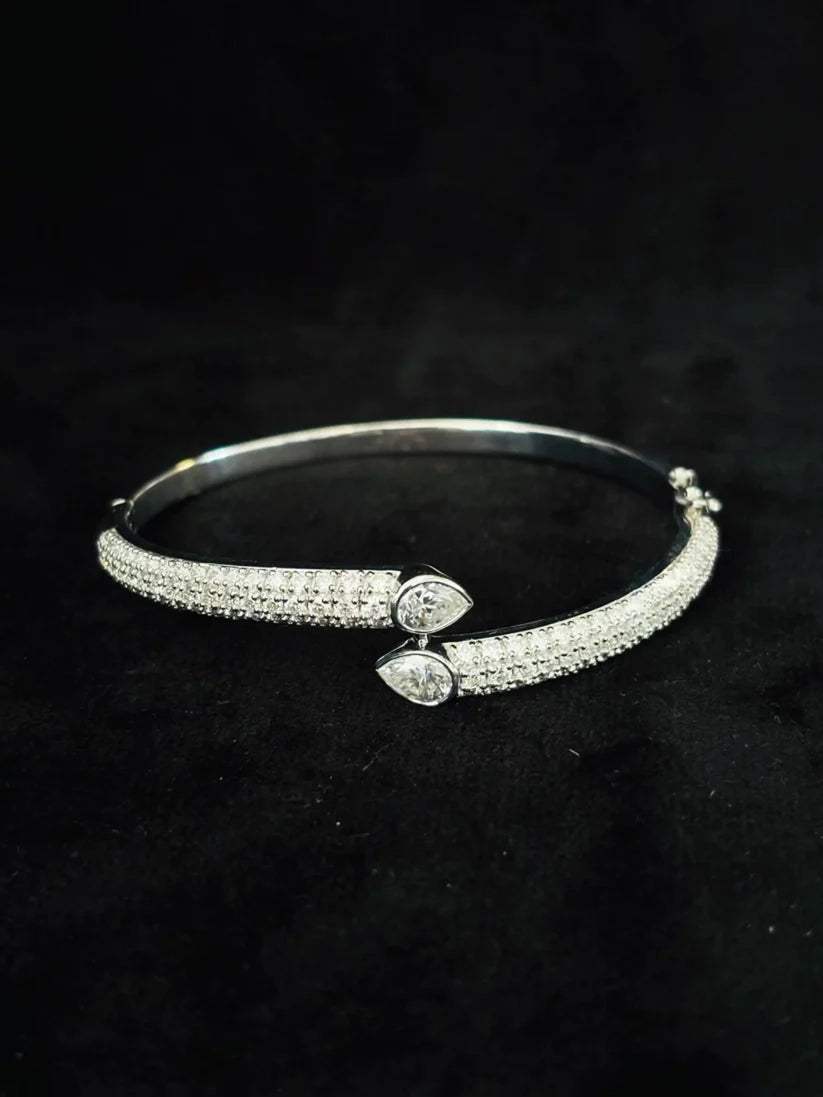 A front view Silver bypass cuff bracelet adorned with pave-set and two pear-cut diamond accents