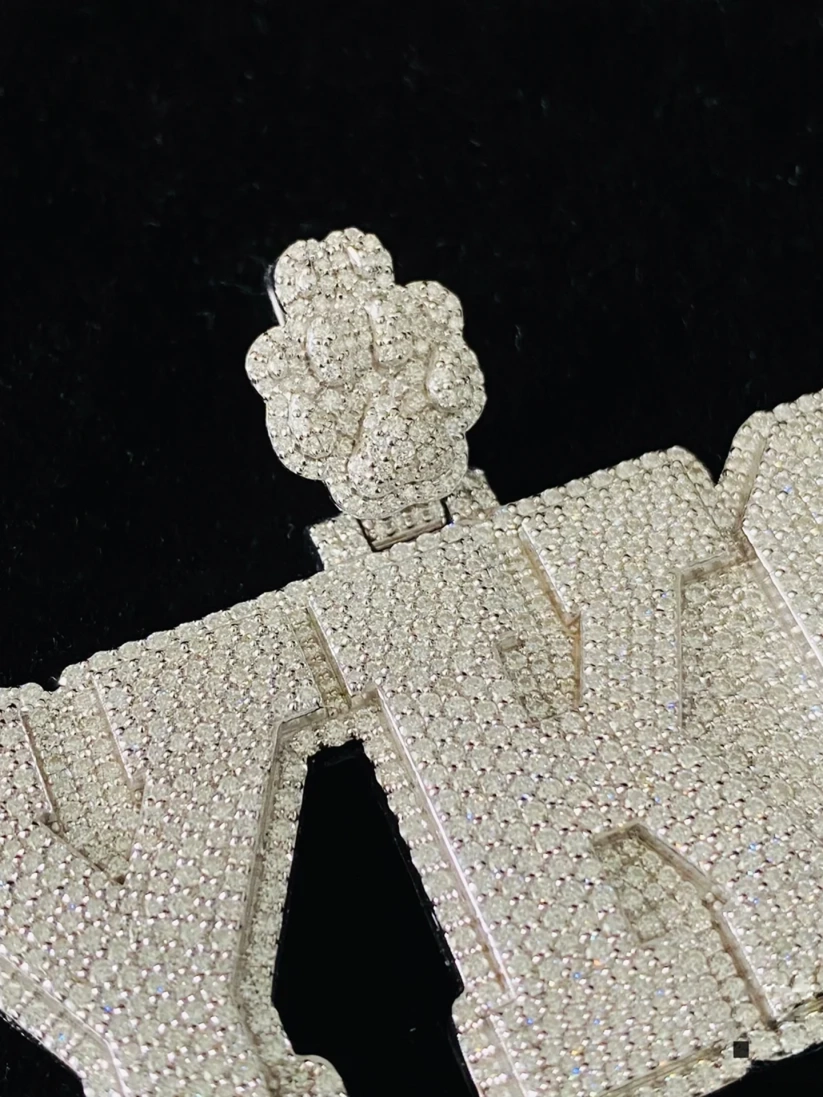  Close-up of a bespoke iced-out diamond nameplate pendant with intricate pave diamond setting.