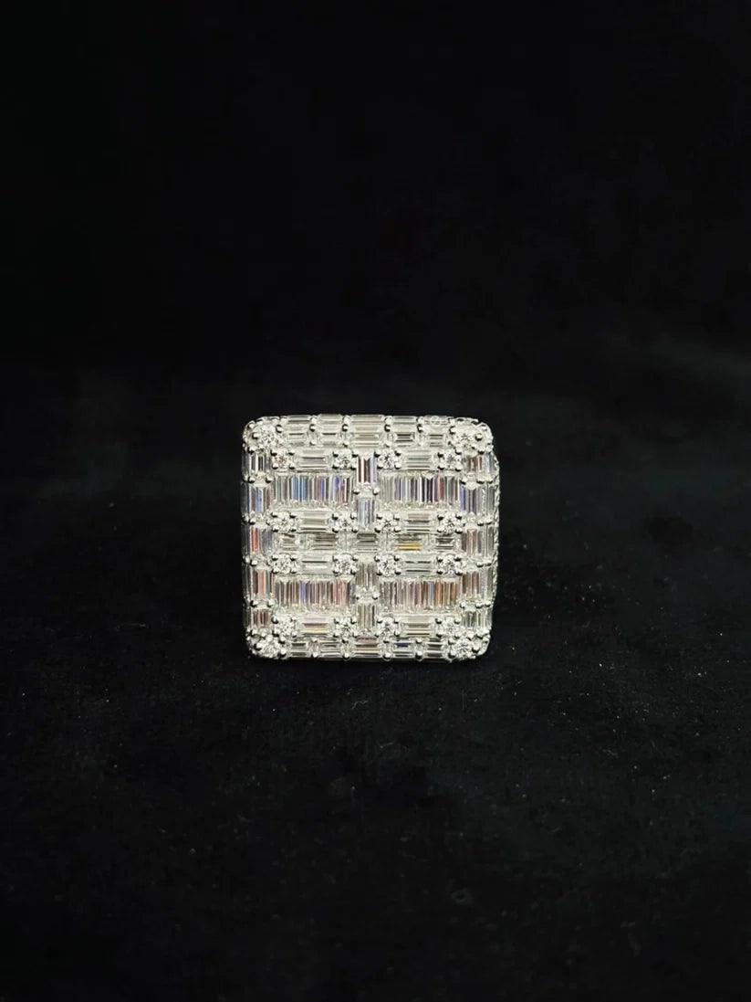 A square-shaped silver ring featuring a textured, woven-like pattern of  baguette-cut diamond
