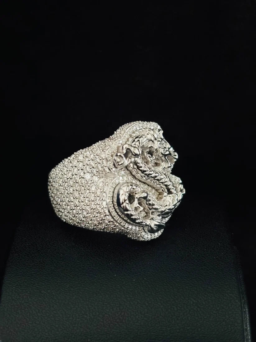 A silver ring featuring a highly detailed, textured dragon head design