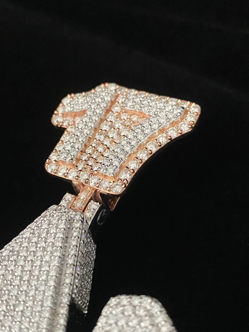 Close-up of a custom diamond hip hop pendant featuring a micro-pave stone setting and a rose gold bail.