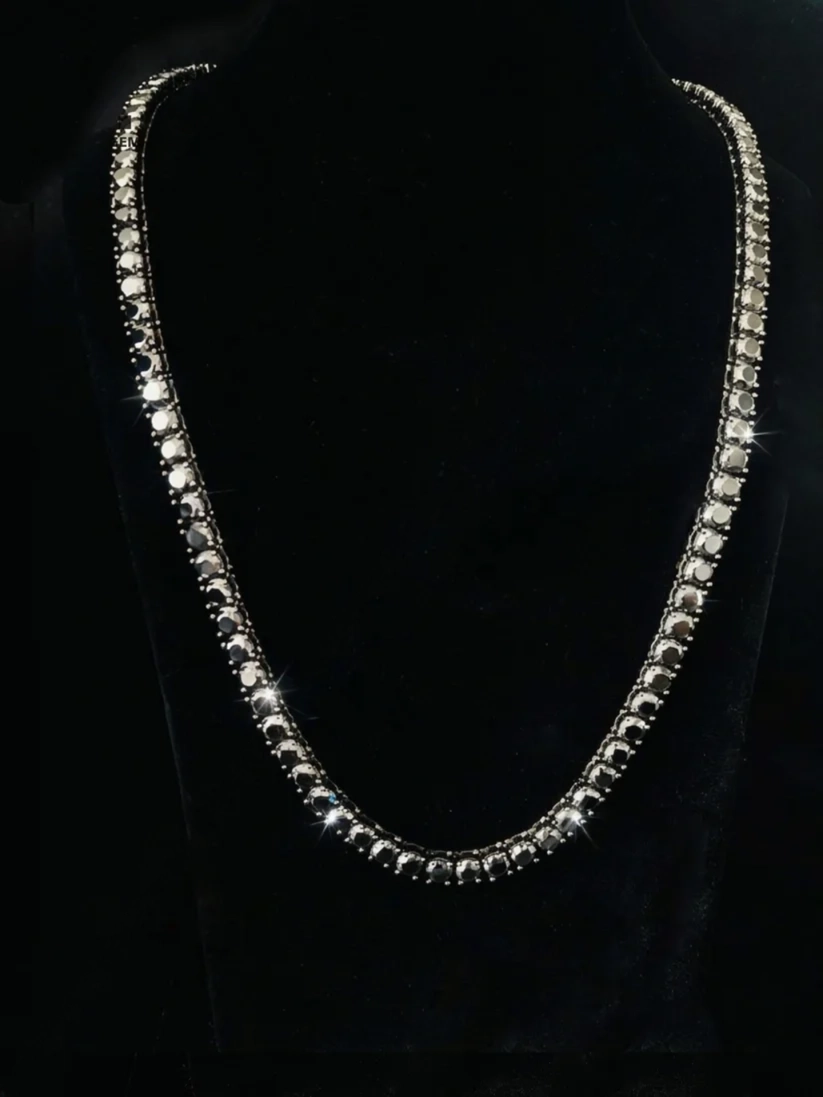 Single-row diamond tennis chain necklace displayed on a black bust mannequin
