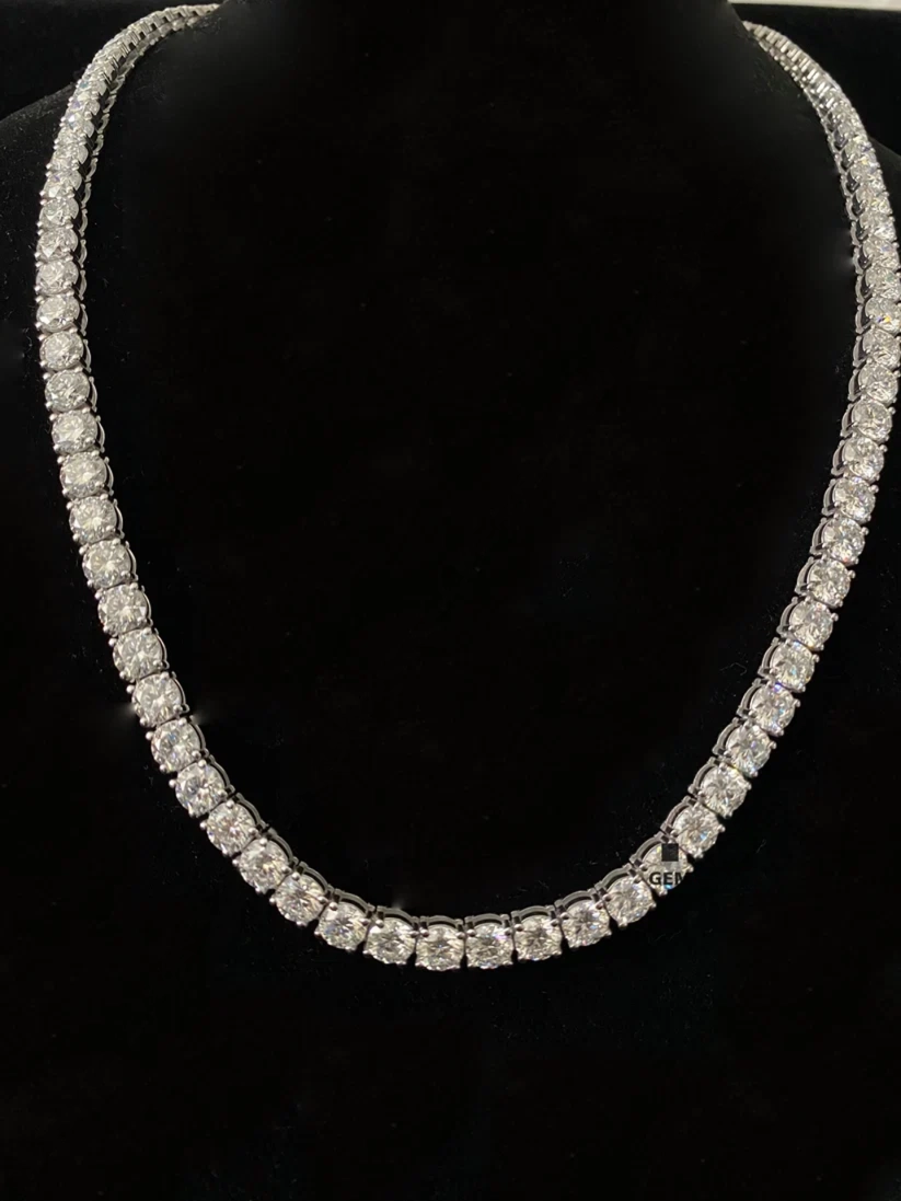 A silver tennis necklace with diamond, displayed on a black velvet mannequin bust