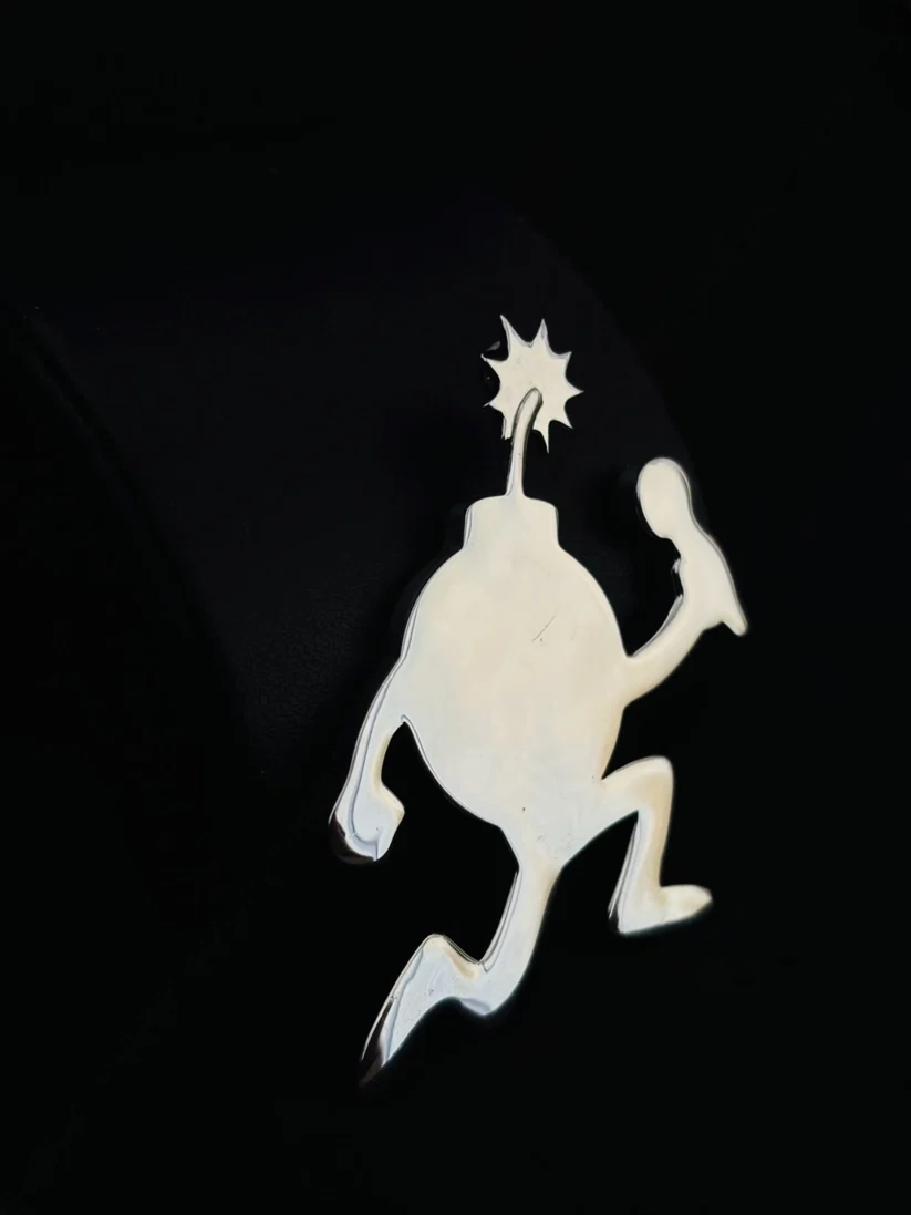 Polished silver running cartoon bomb pendant necklace charm on a black background.