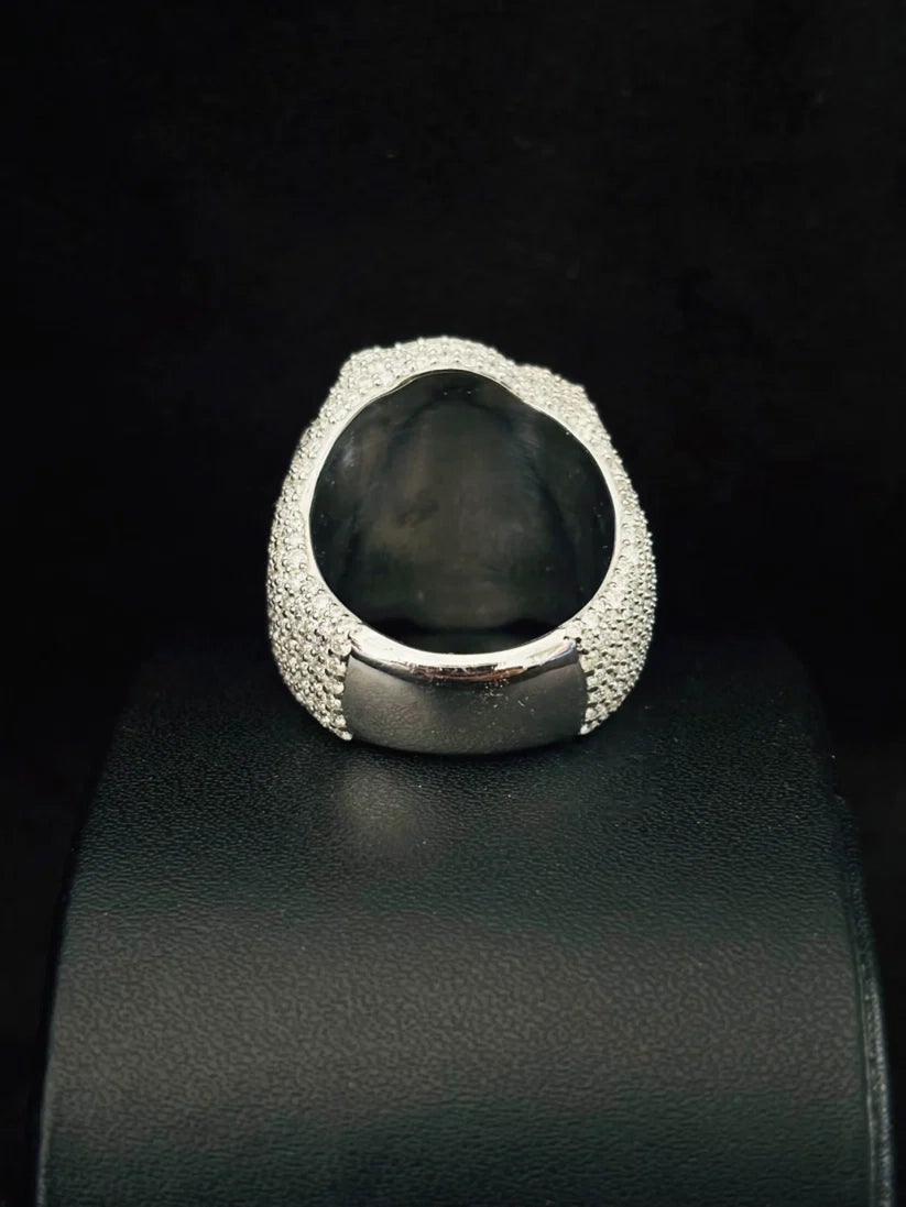 Back view of a thick silver iced-out dome ring paved with shimmering micro stones