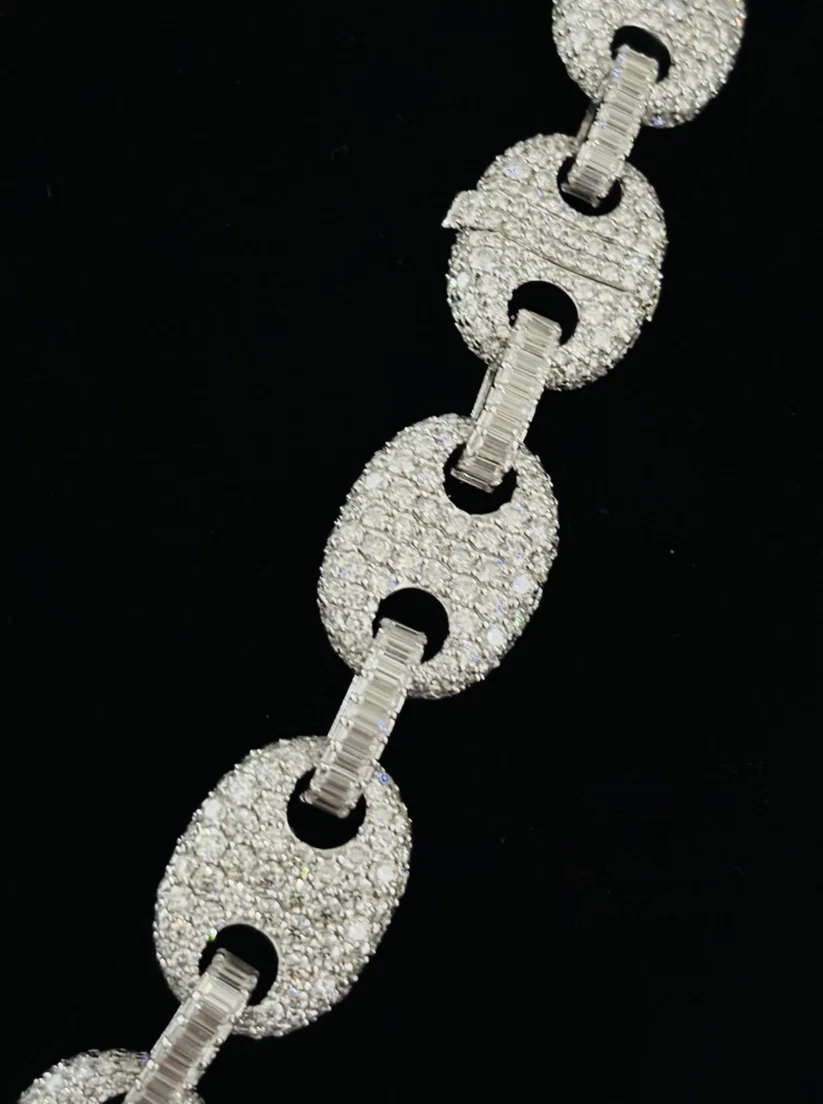 A close-up of a silver chain link Chain featuring large, oval pave-set links diamond 