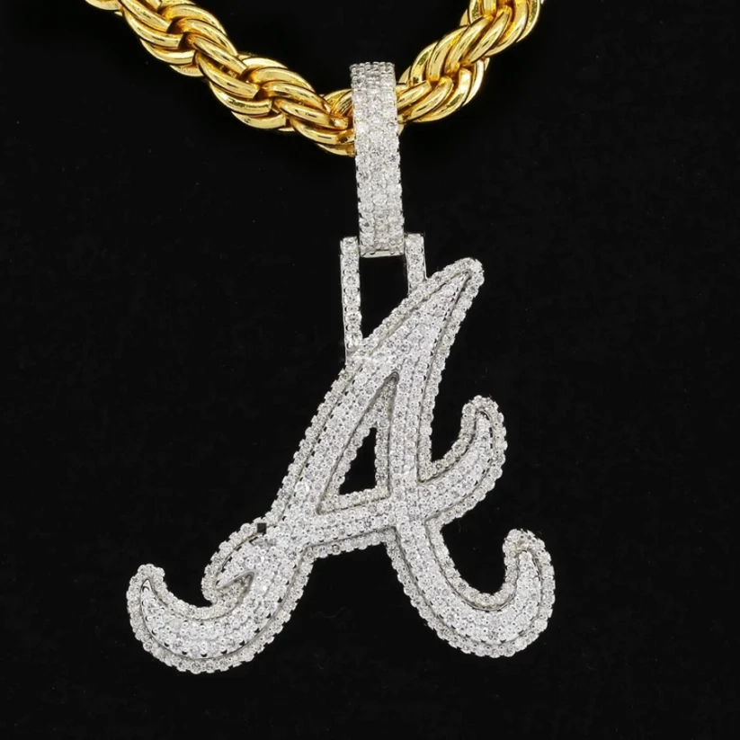 front view Iced-out cursive letter A pendant necklace in white gold with diamonds on a thick yellow gold rope chain.