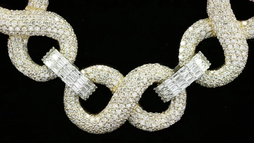 close up of a Iced out infinity link chain in yellow gold with pave diamonds