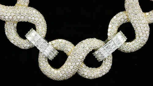 close up of a Iced out infinity link chain in yellow gold with pave diamonds