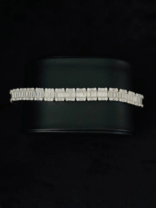A close-up view Silver diamond baguette tennis bracelet with channel-set rectangular link layout on a black background