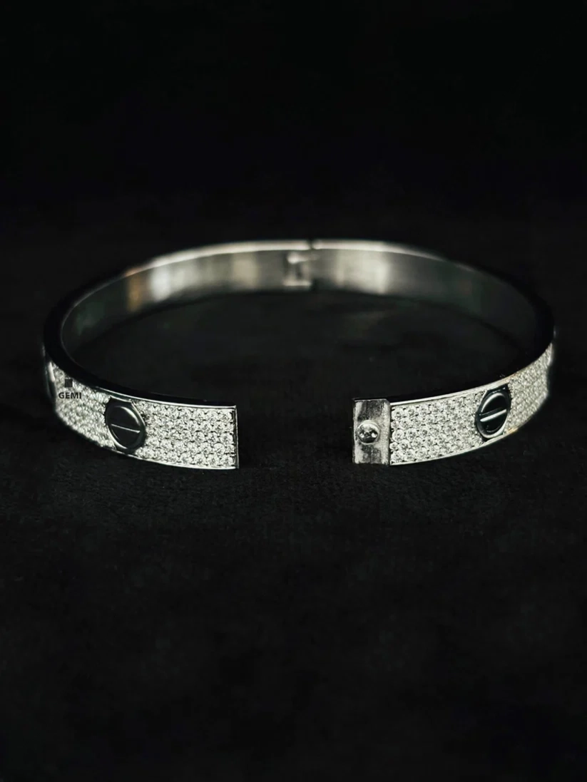 Silver paved diamond screw bangle bracelet with open hinge closure on black background
