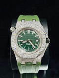 A luxury wristwatch with a green dial, green rubber strap, and a heavily embellished diamond-encrusted silver-tone case and watch
