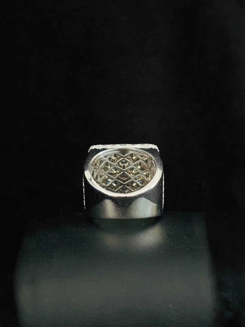 A silver signet-style ring with a square face and an intricate geometric lattice pattern on the top