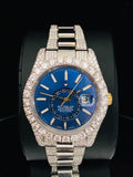 Diamond paved Rolex Sky-Dweller watch featuring a vibrant blue face and iced out bezel and lugs