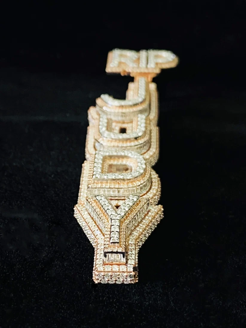 Custom iced-out vertical name pendant in rose gold with baguette diamonds.