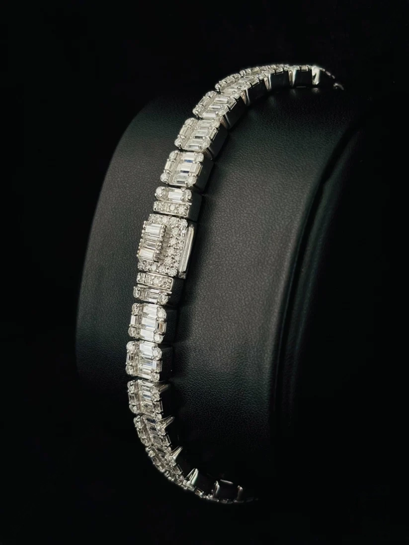 diamond bracelet featuring rectangular step cut stones and brilliant round pave accents