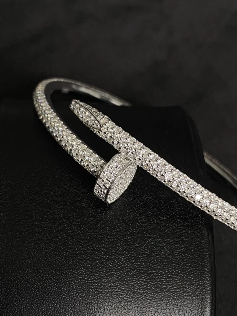 A close-up view silver pave bangle bracelet with a matching round bezel-set stone closure