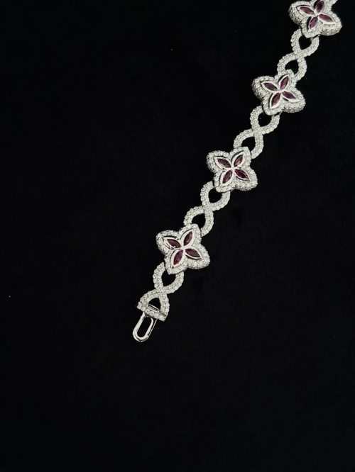A silver chain bracelet featuring four-link floral motifs with deep red inlay, set 