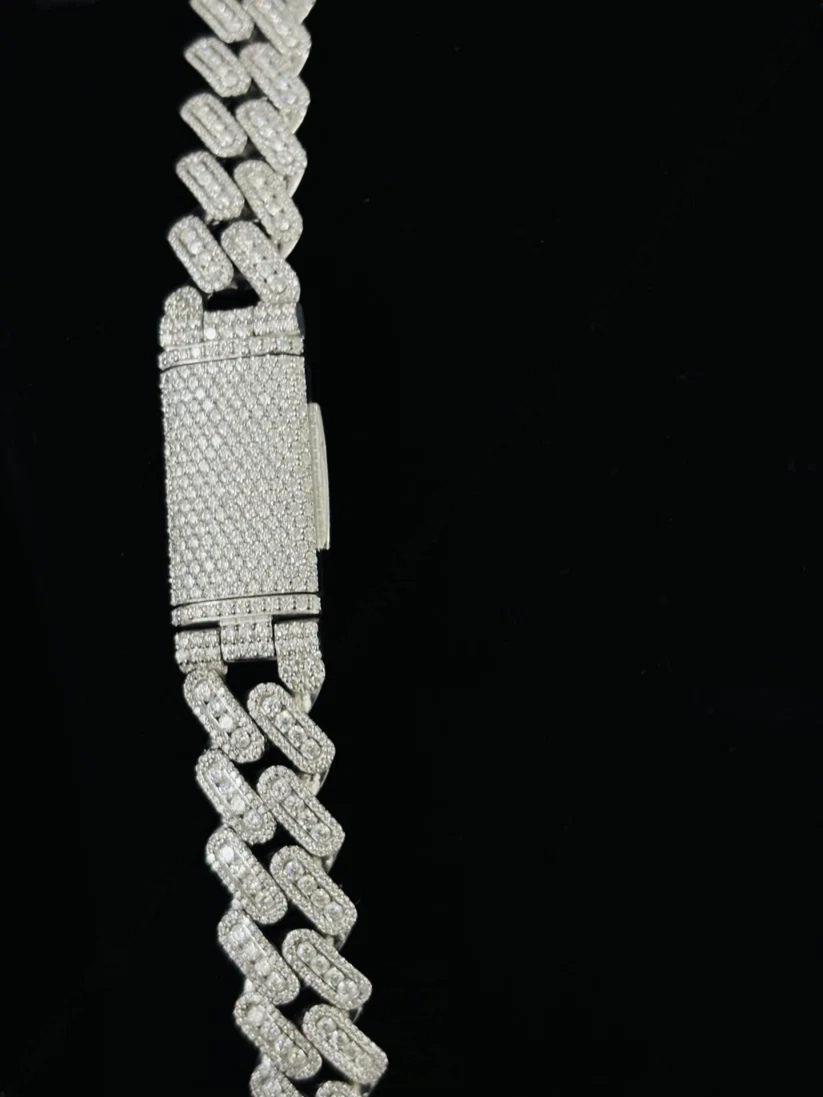 Close-up of a diamond-encrusted silver Cuban link chain necklace with an iced-out box clasp