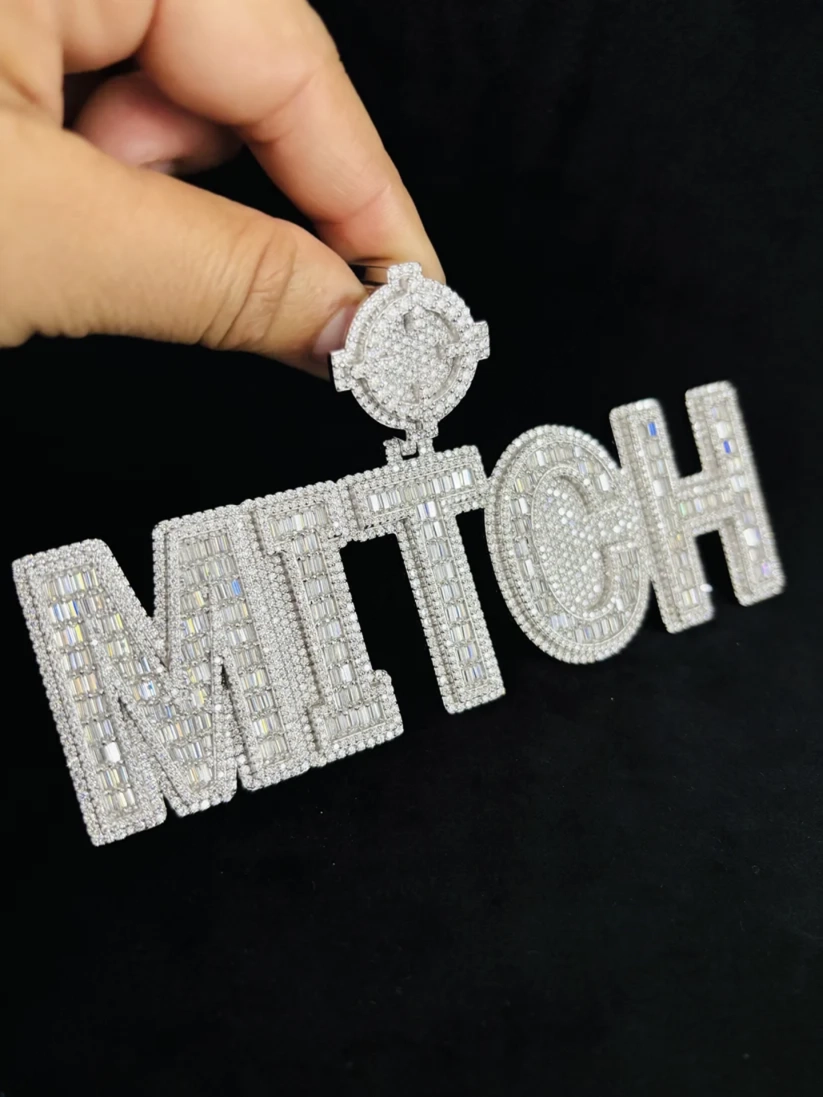 Custom iced out name pendant necklace spelling "MITCH" in silver with baguette and round cut diamonds.