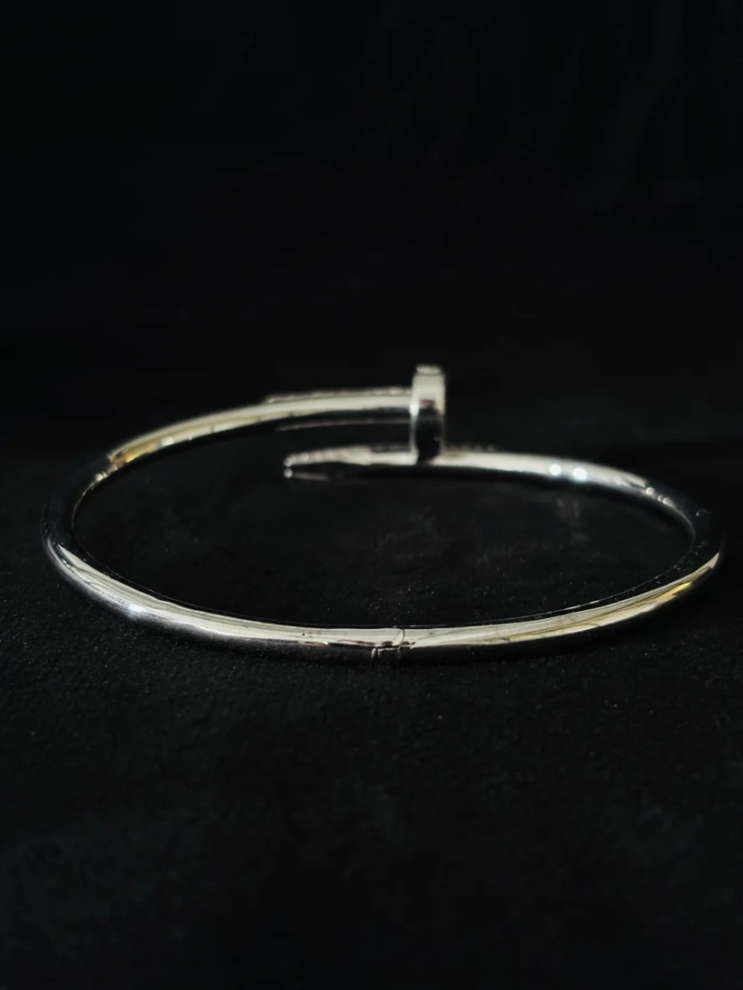 A polished silver metal bangle bracelet with a textured bracelet gift for her