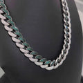Silver Miami Cuban link chain necklace paved with white diamonds and green emeralds