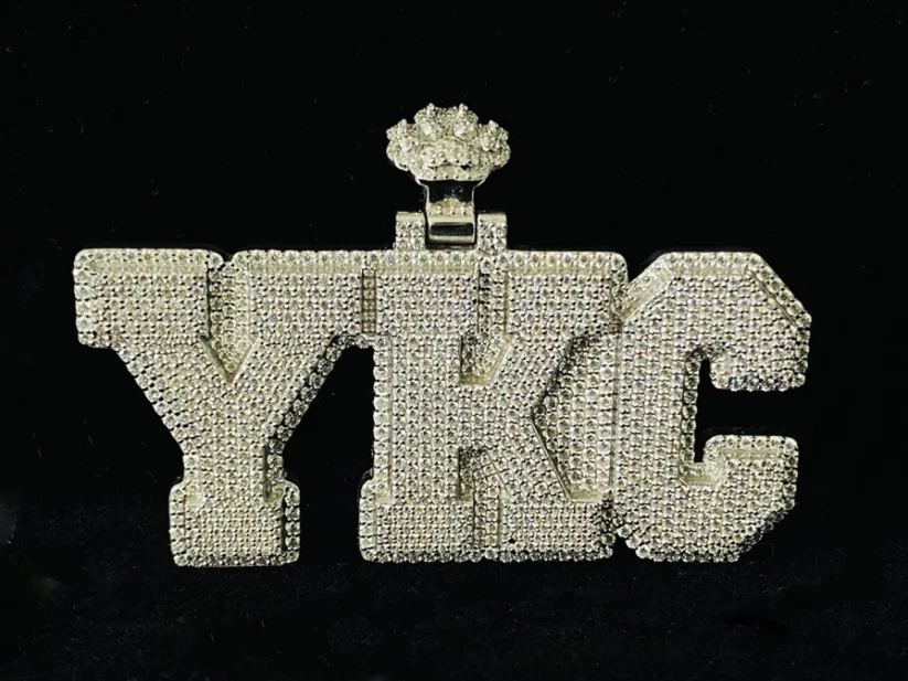 front view Custom iced-out YKC block letter pendant necklace in white gold with pave diamonds.