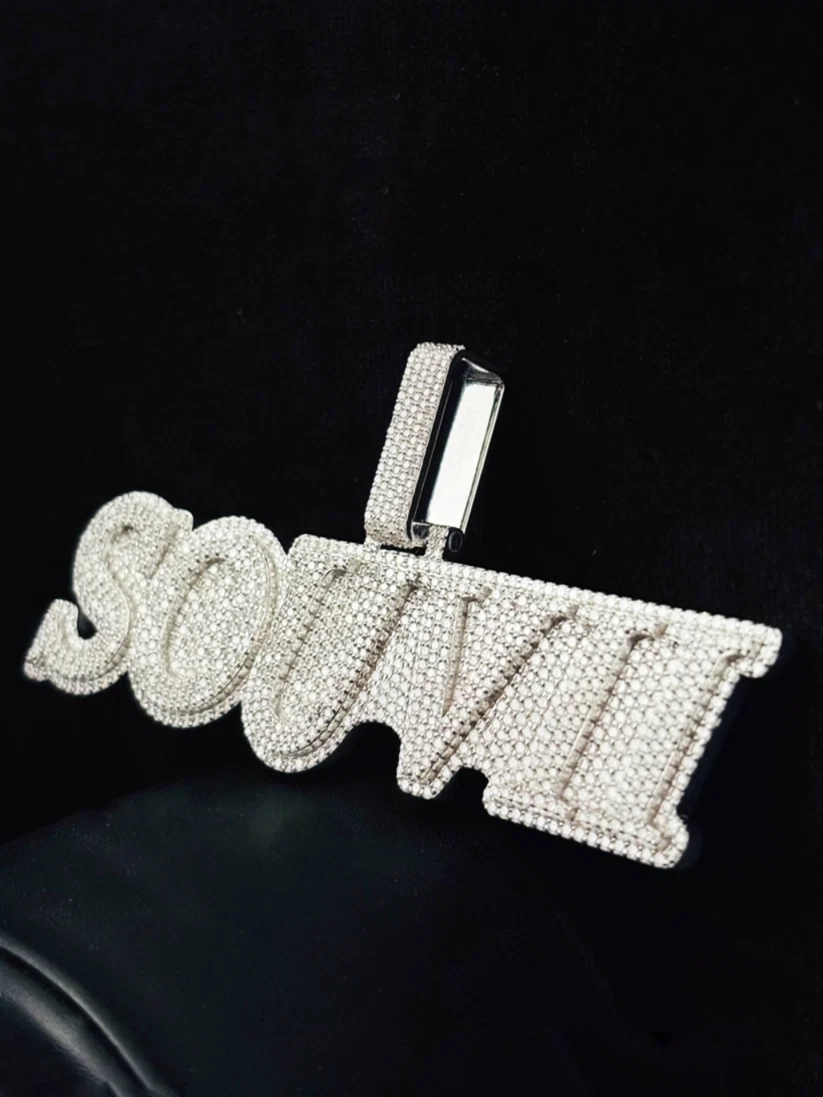 Custom diamond name pendant necklace reading "SOUVII" in cursive script lettering