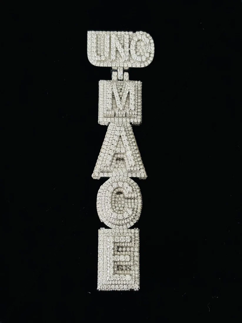 front view A vertical rhinestone-embellished letter patch spelling 'UNC MADE' in white on a solid black background