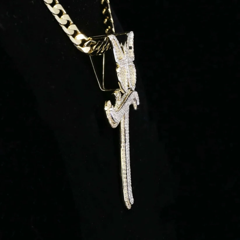 Side view of a gold cuban link chain featuring a custom iced-out diamond pendant